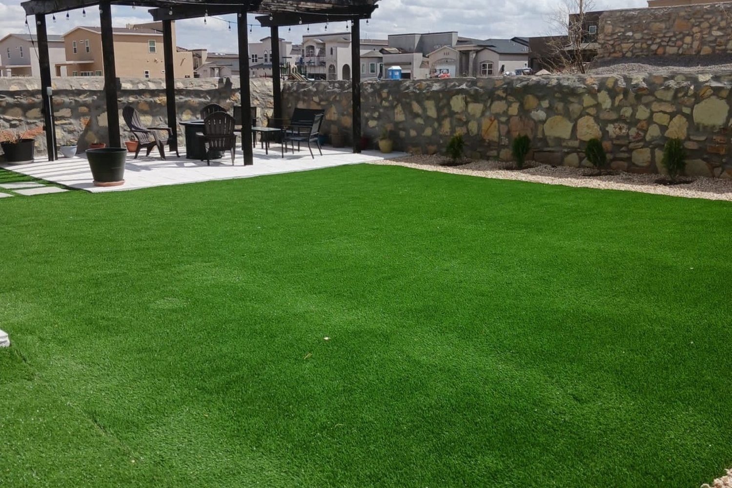 Wide artificial turf lawn with a shade pergola